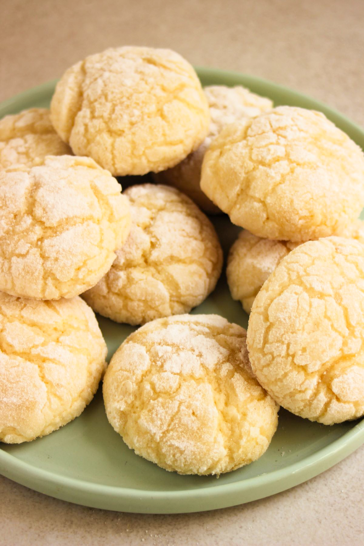 Lemon crinkle cookies on a light aqua plate.