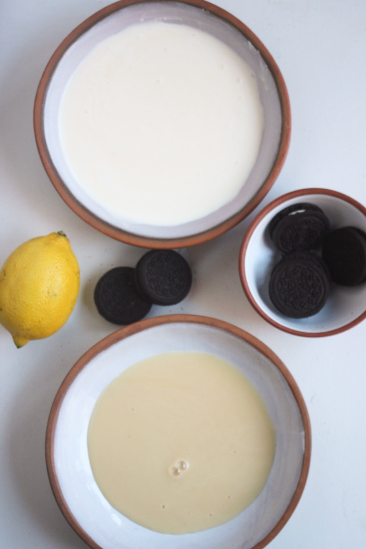 Top view of lemon mousse oreo ingredients on a white surface.
