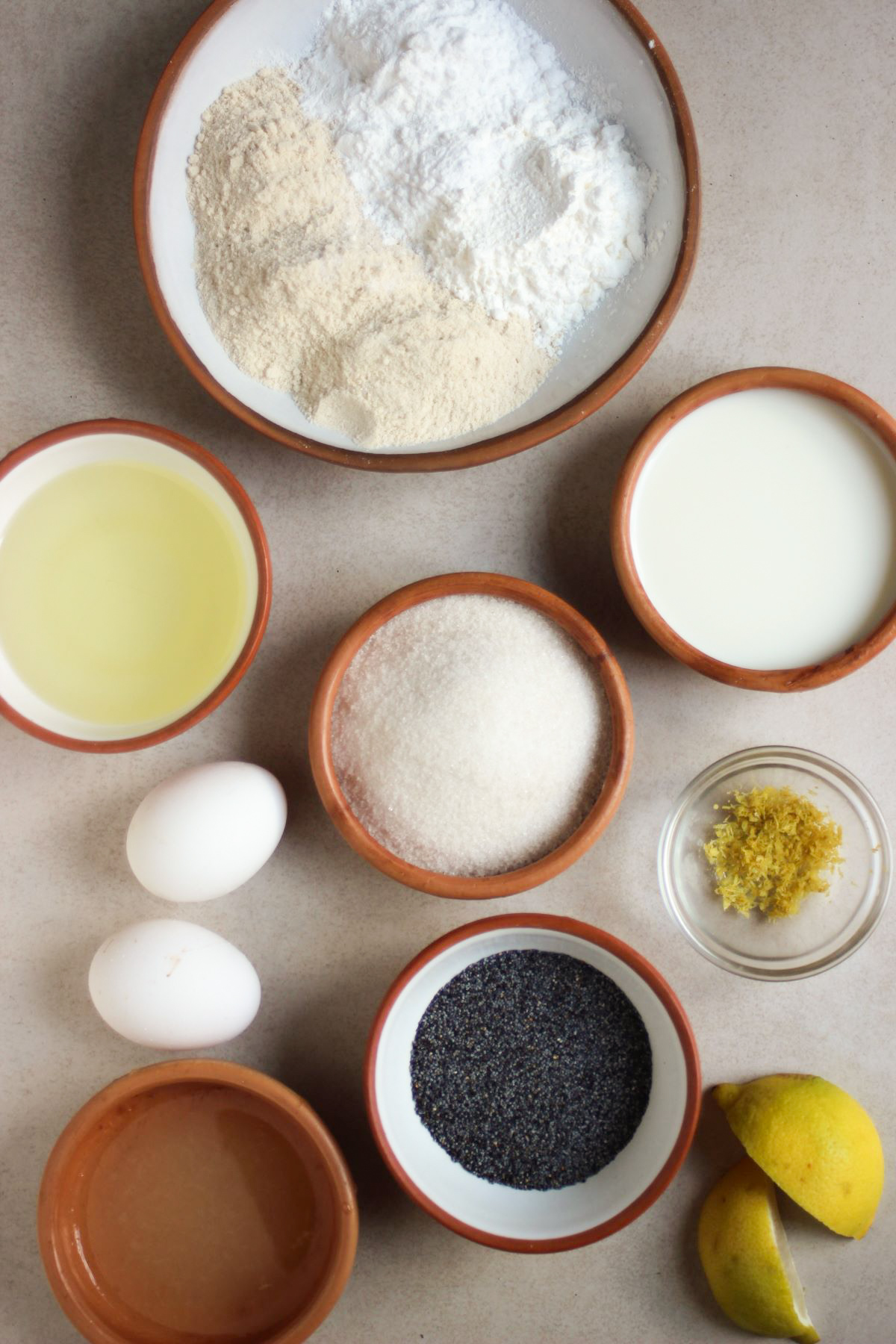 Lemon muffins ingredients on a white surface seen from above.