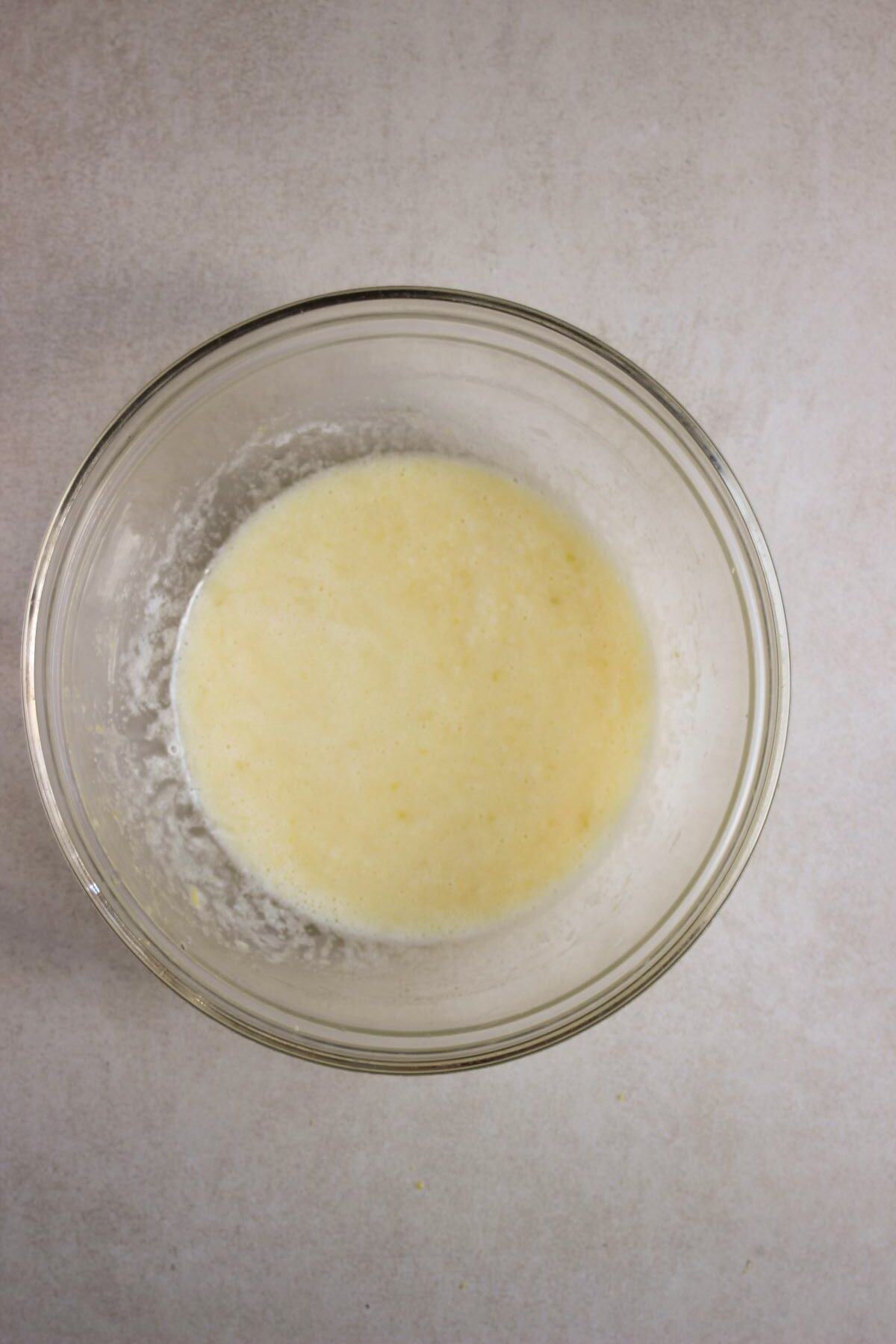 Glass bowl with a light yellow liquid.