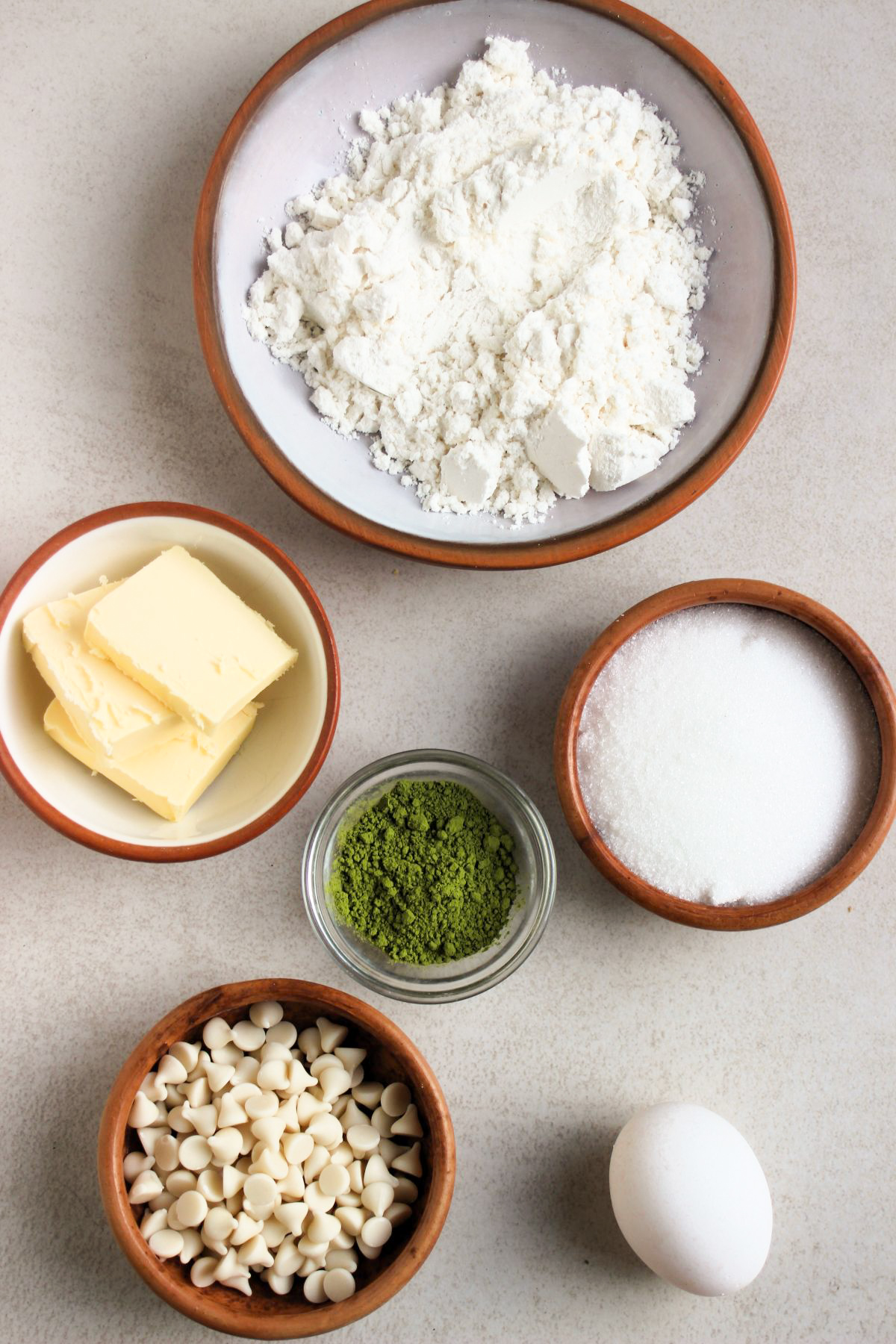 Matcha cookies ingredients on a white surface seen from above.