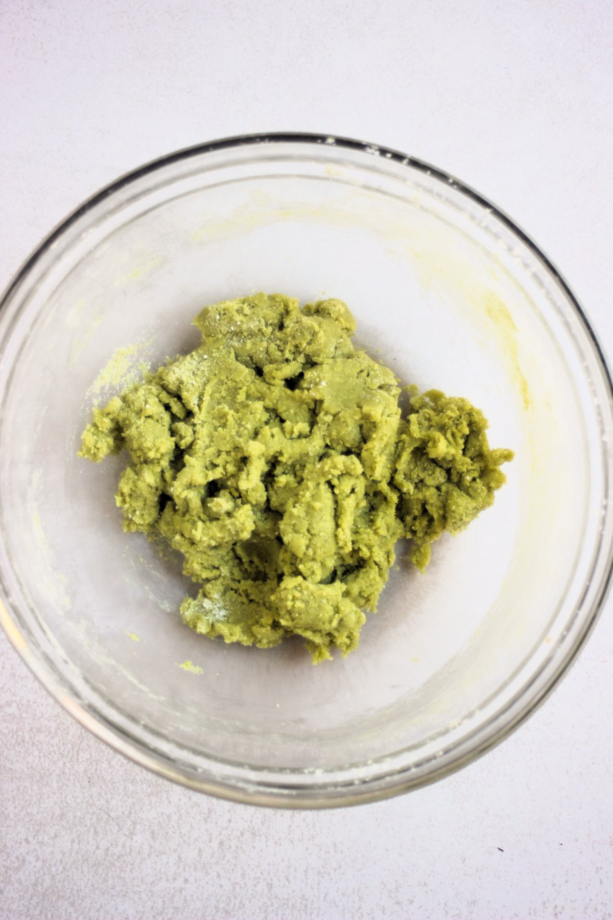 Glass bowl with a green cookie dough.