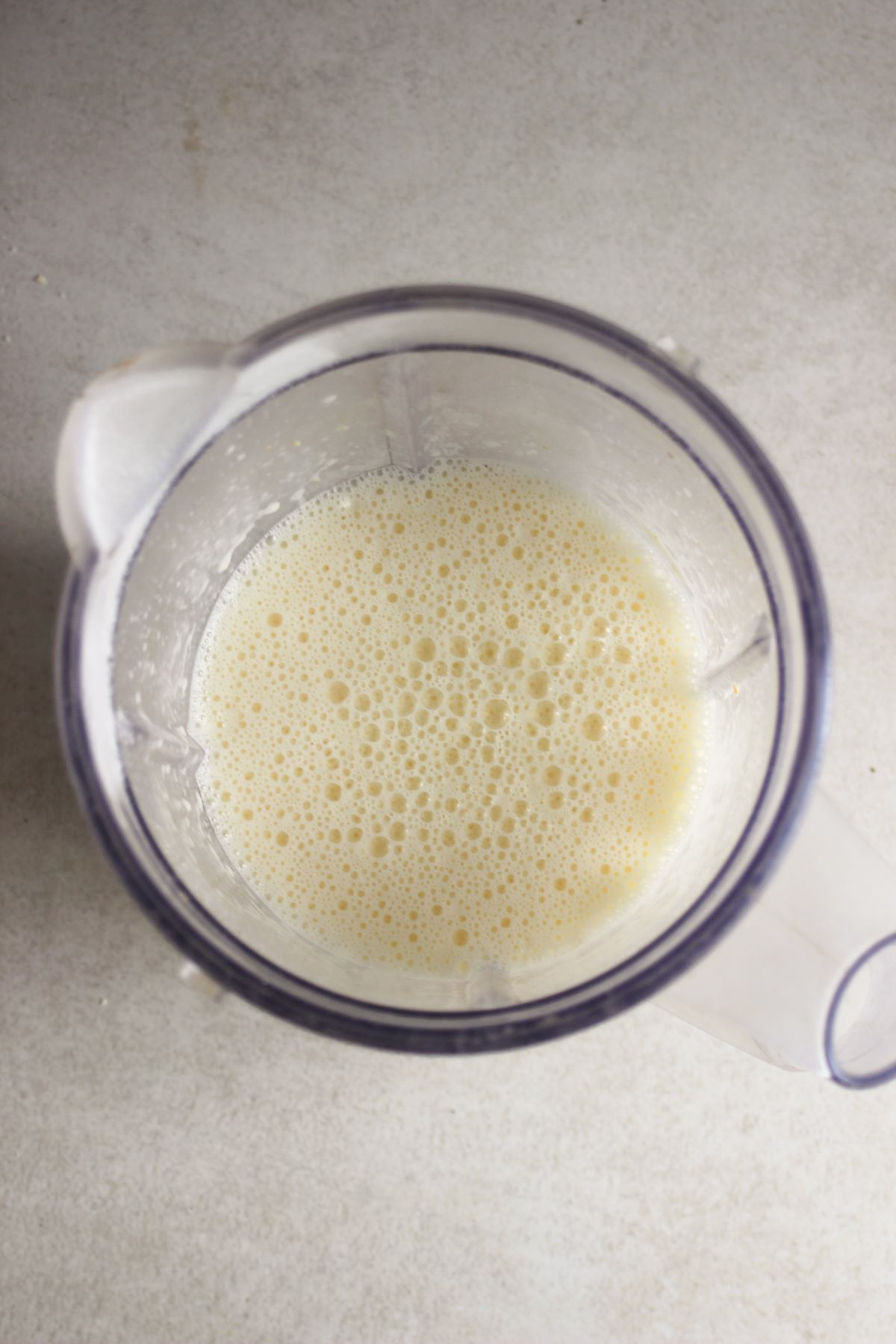 A blender with a white liquid seen from above.