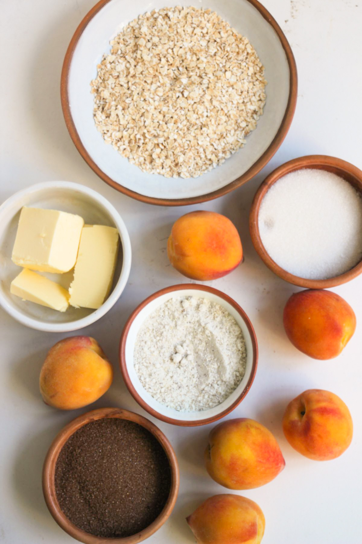 Easy Peach Crisp ingredients on a white surface seen from above.
