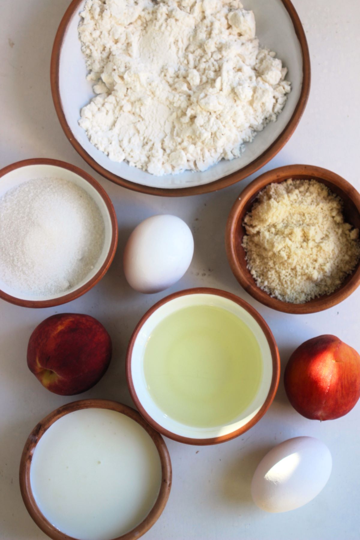 Peach streusel muffin ingredients on a white surface seen from above.