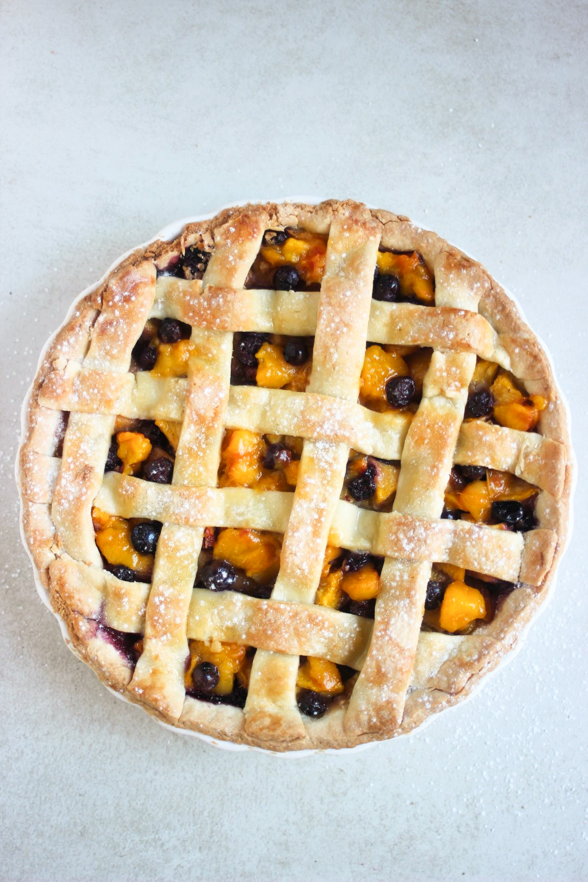 Peach pie on a grey surface seen from above.