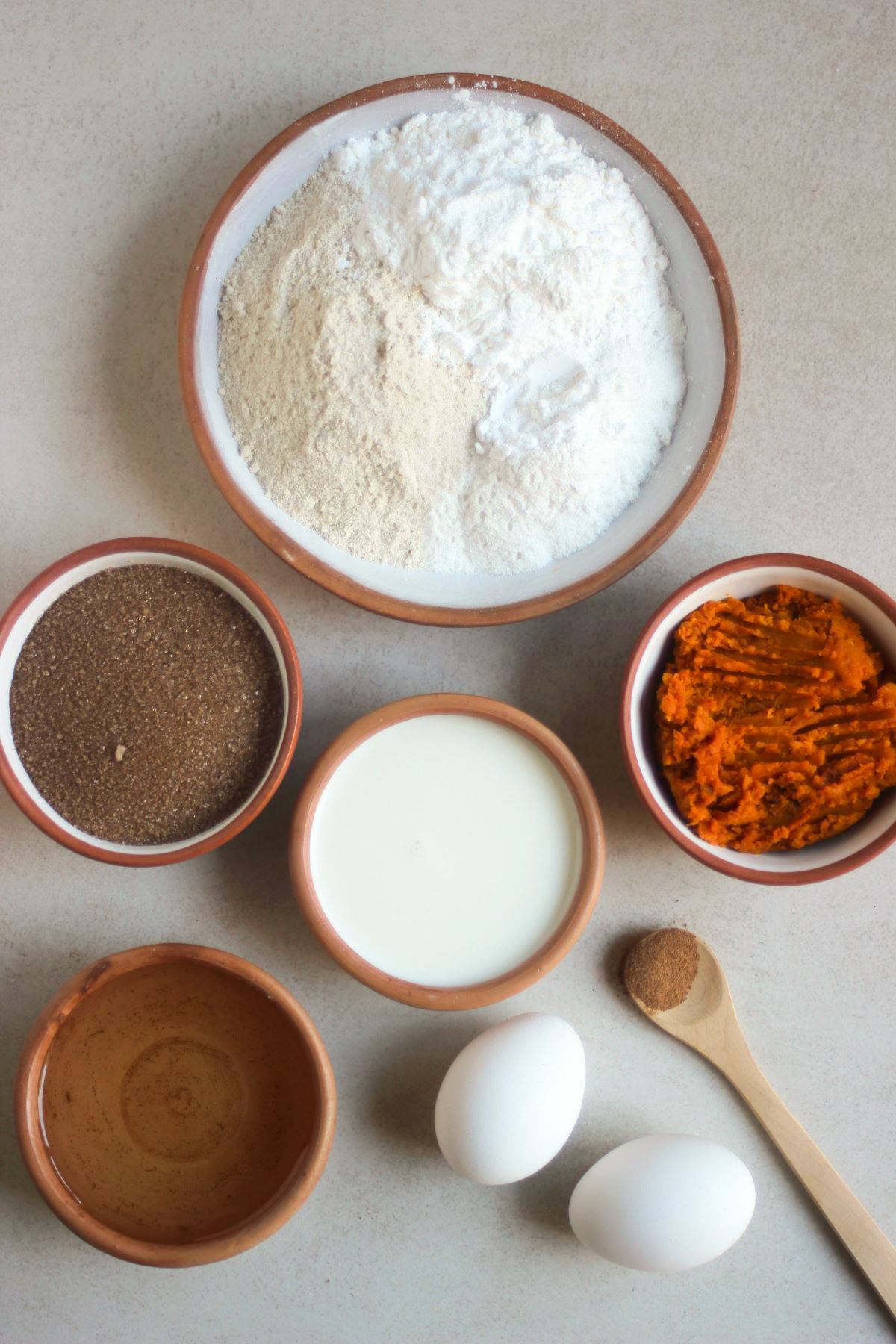 Pumpkin bread ingredients on a white surface seen from above.