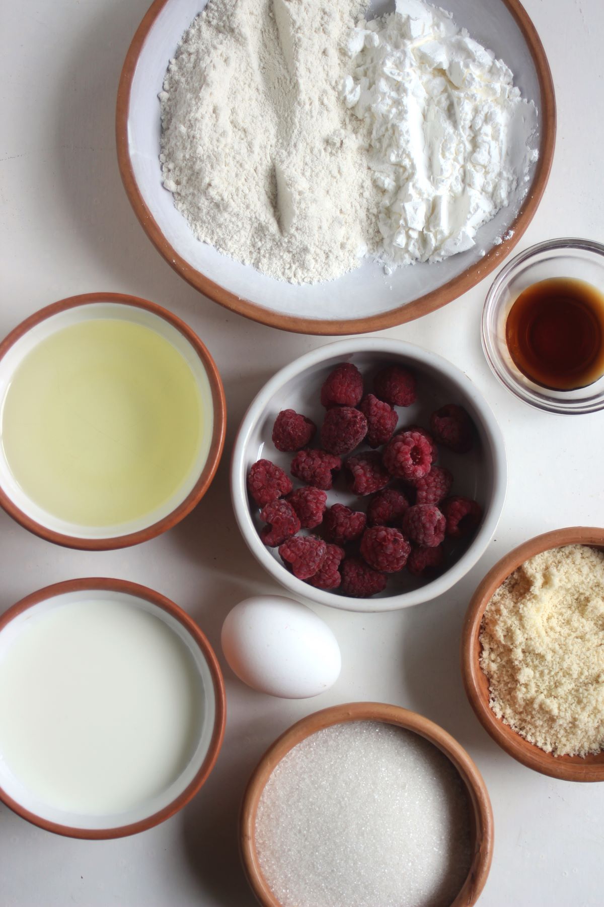 Raspberry loaf cake ingredients on a white surface seen from above.