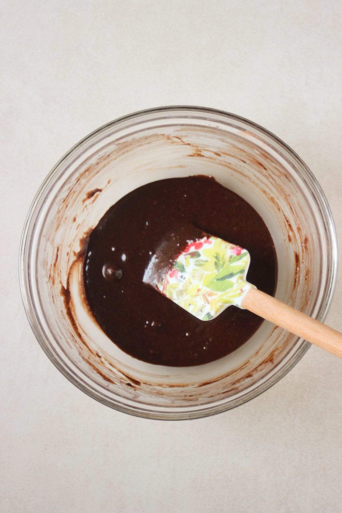 Glass bowl with a chocolate mixture and a rubber spatula.