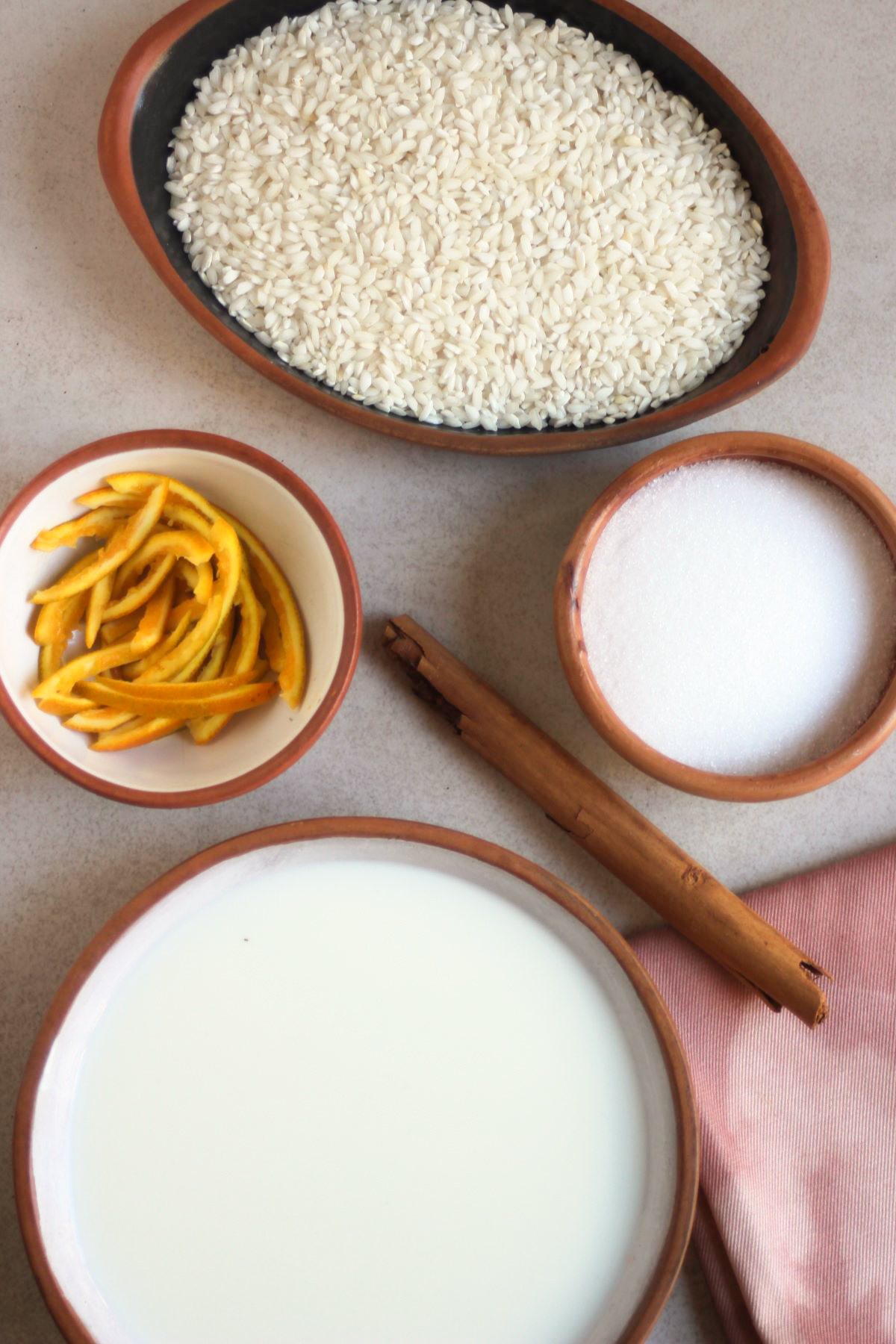 Rice pudding ingredients on a white surface seen from above.