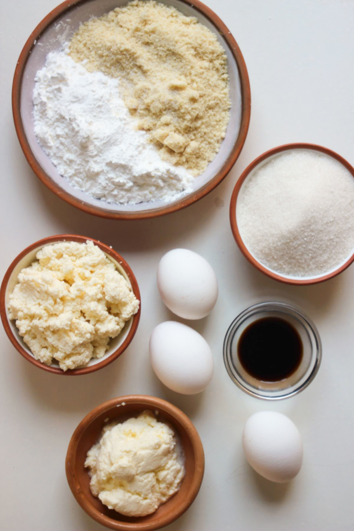 Top view of almond ricotta cake ingredients on a white surface.