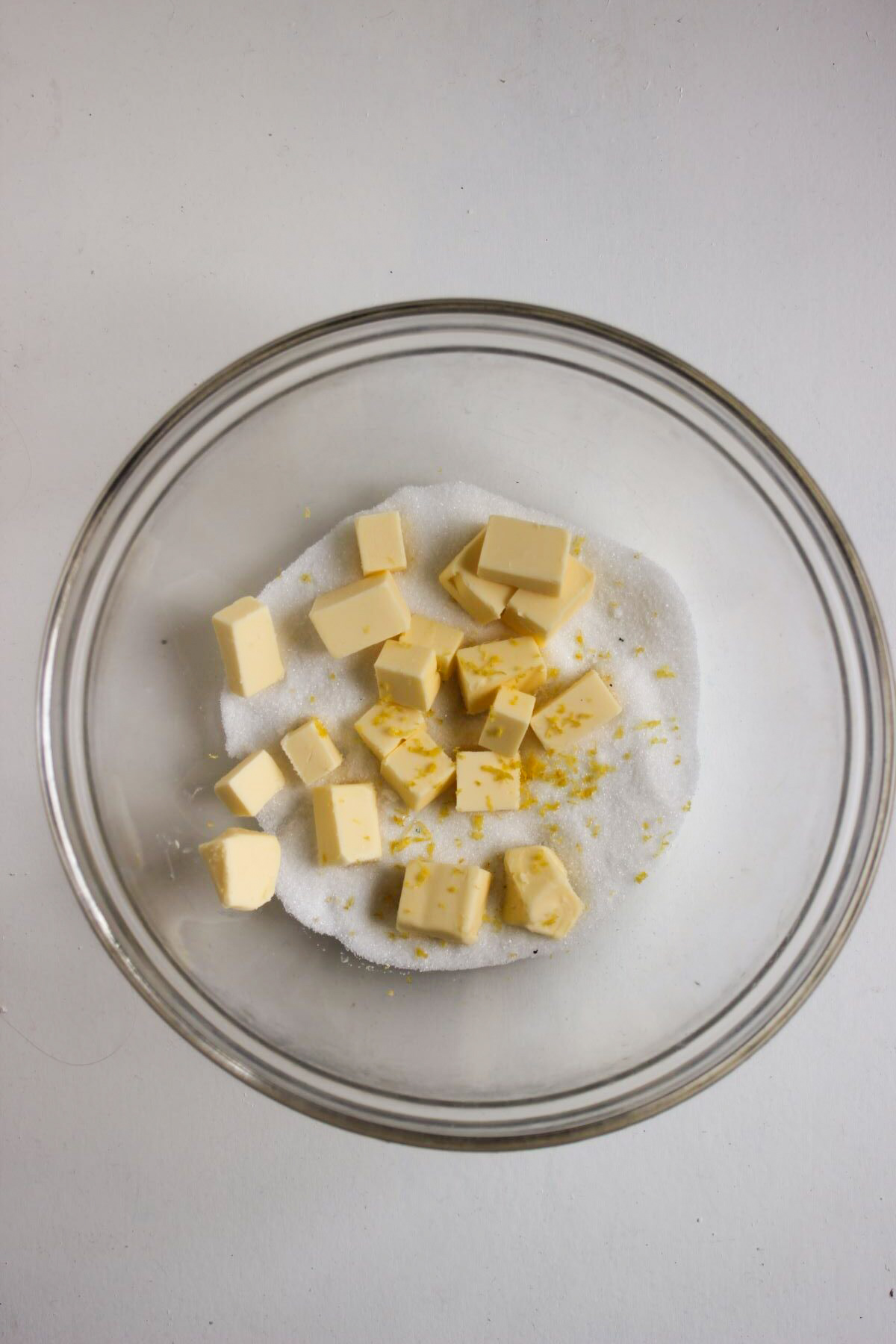 Glass bowl with sugar, butter, and lemon zest.
