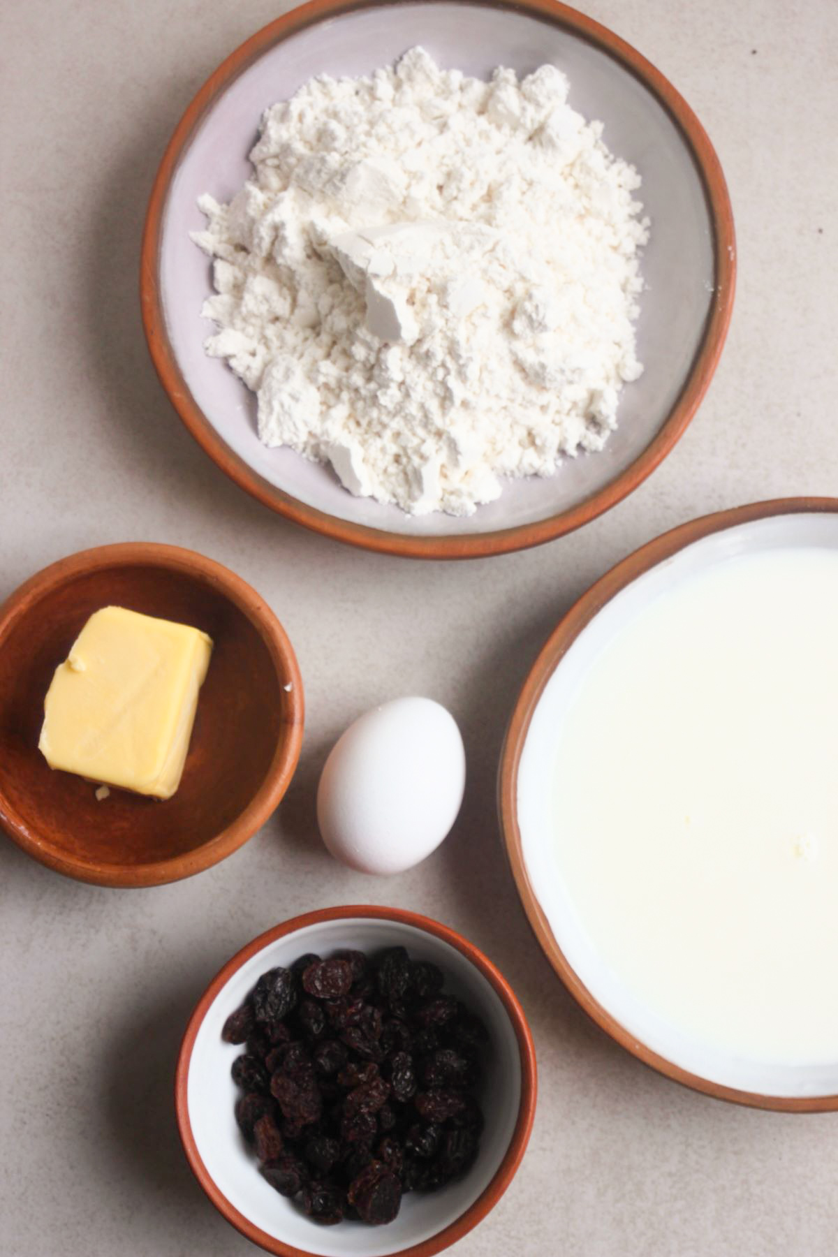 Soda bread with raisins ingredients on a white surface seen from above.