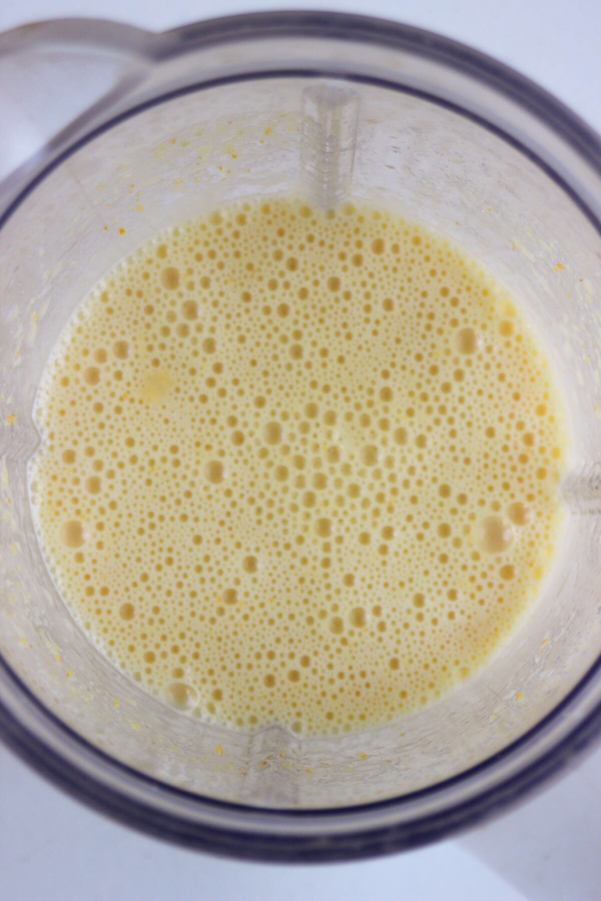 Top view of a blender with a light-yellow liquid inside.
