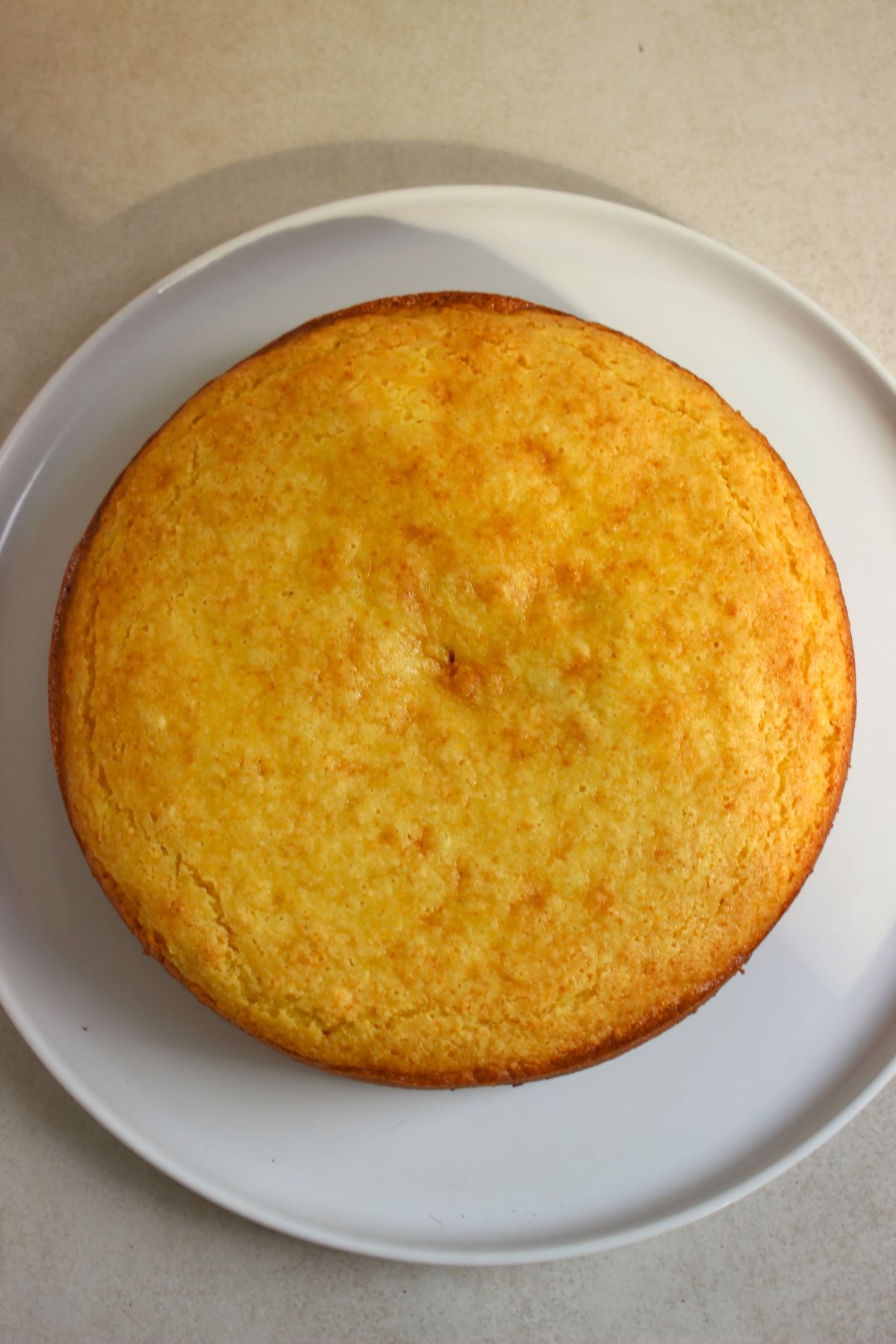 Orange cake on a white plate seen from above.