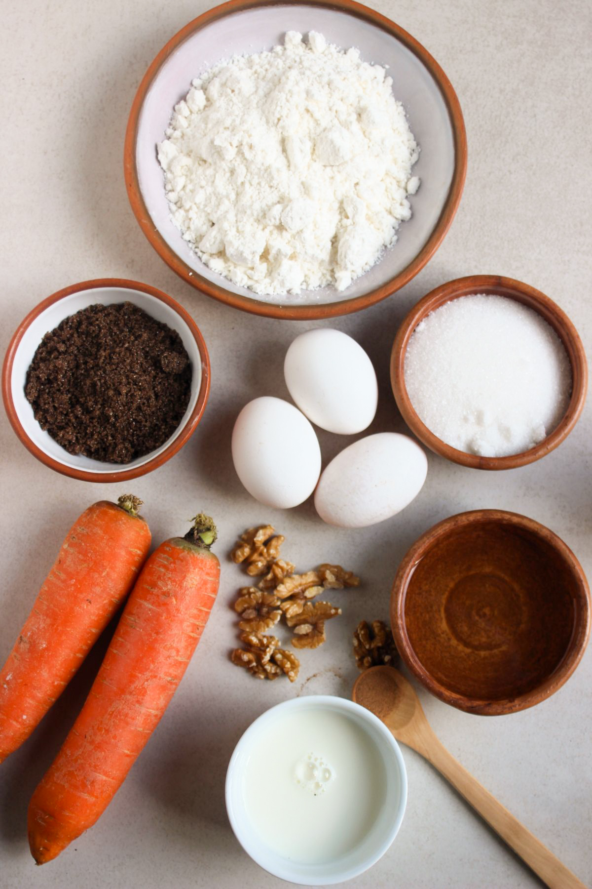 Top view of carrot loaf cake ingredients on a white surface.