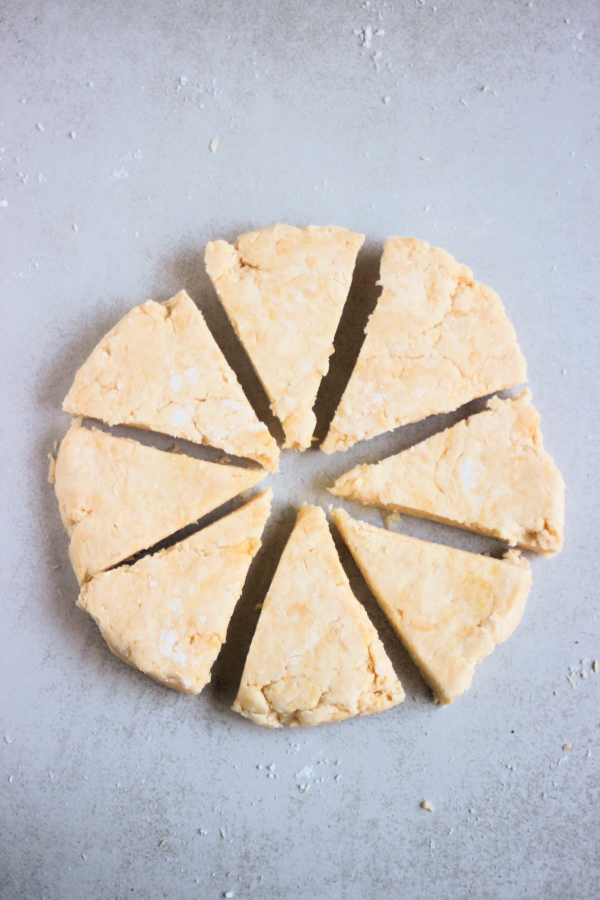 Circle of dough for cheese scones cut into triangles.