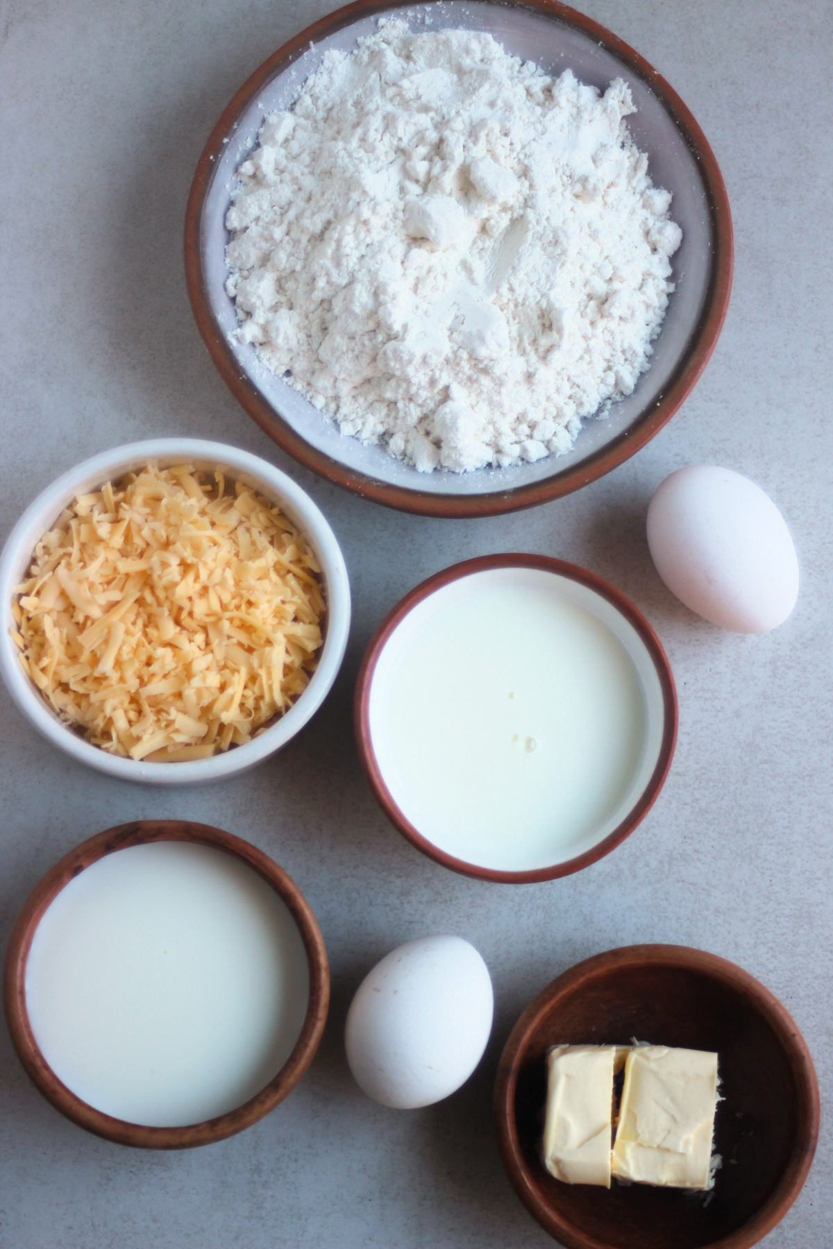 Top view of cheese scones ingredients on a white surface.