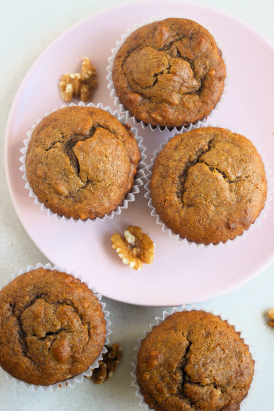 Top view of sweet potato muffins, some on a pink plate.