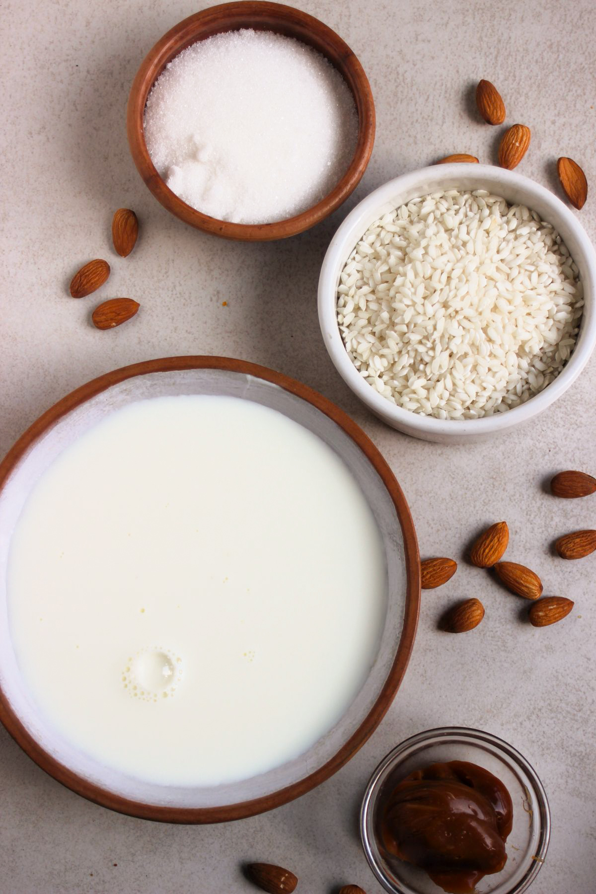 Top view of rice pudding ingredients on a white surface.