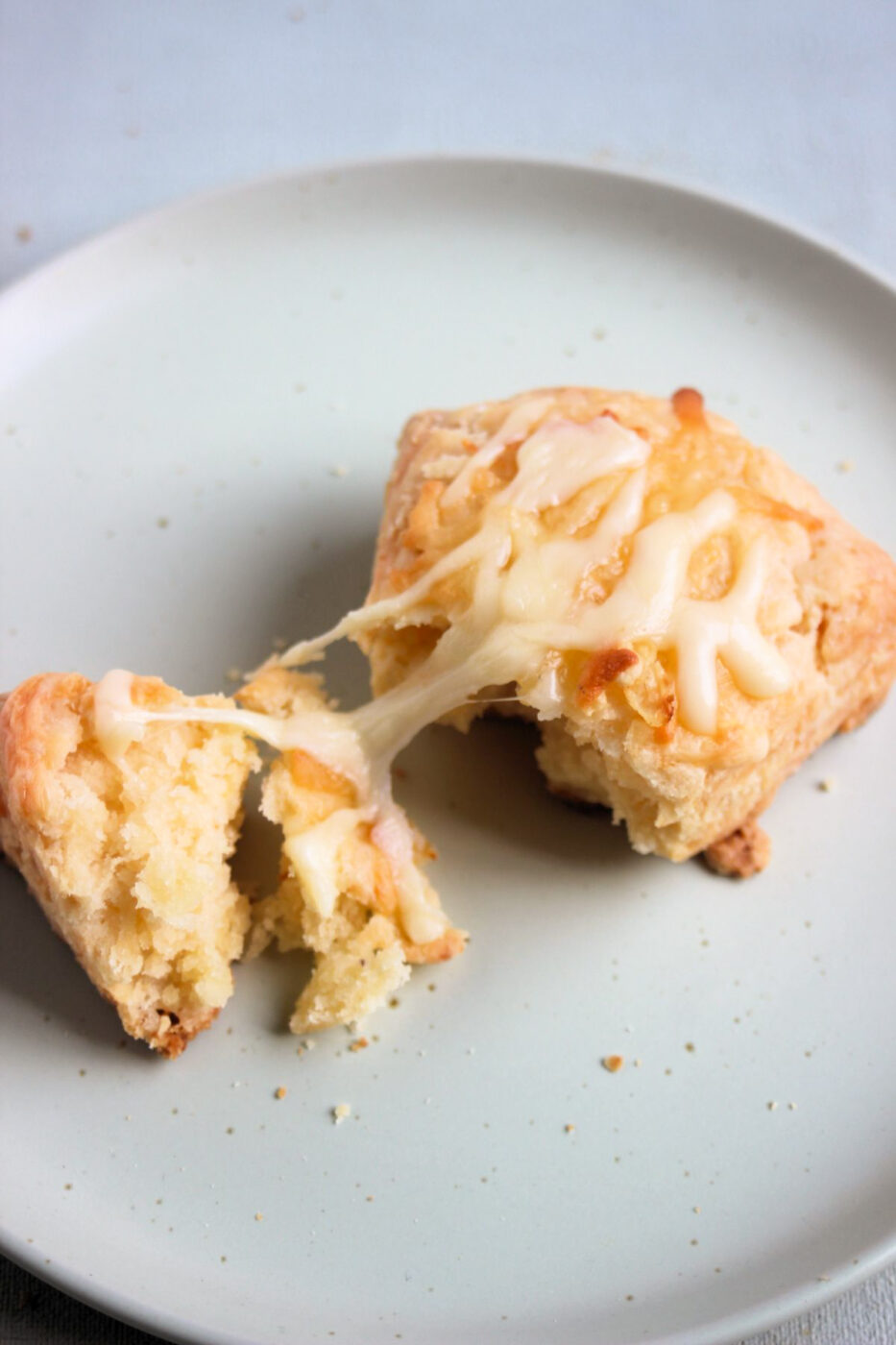A cheese scon cut in half on a plate.