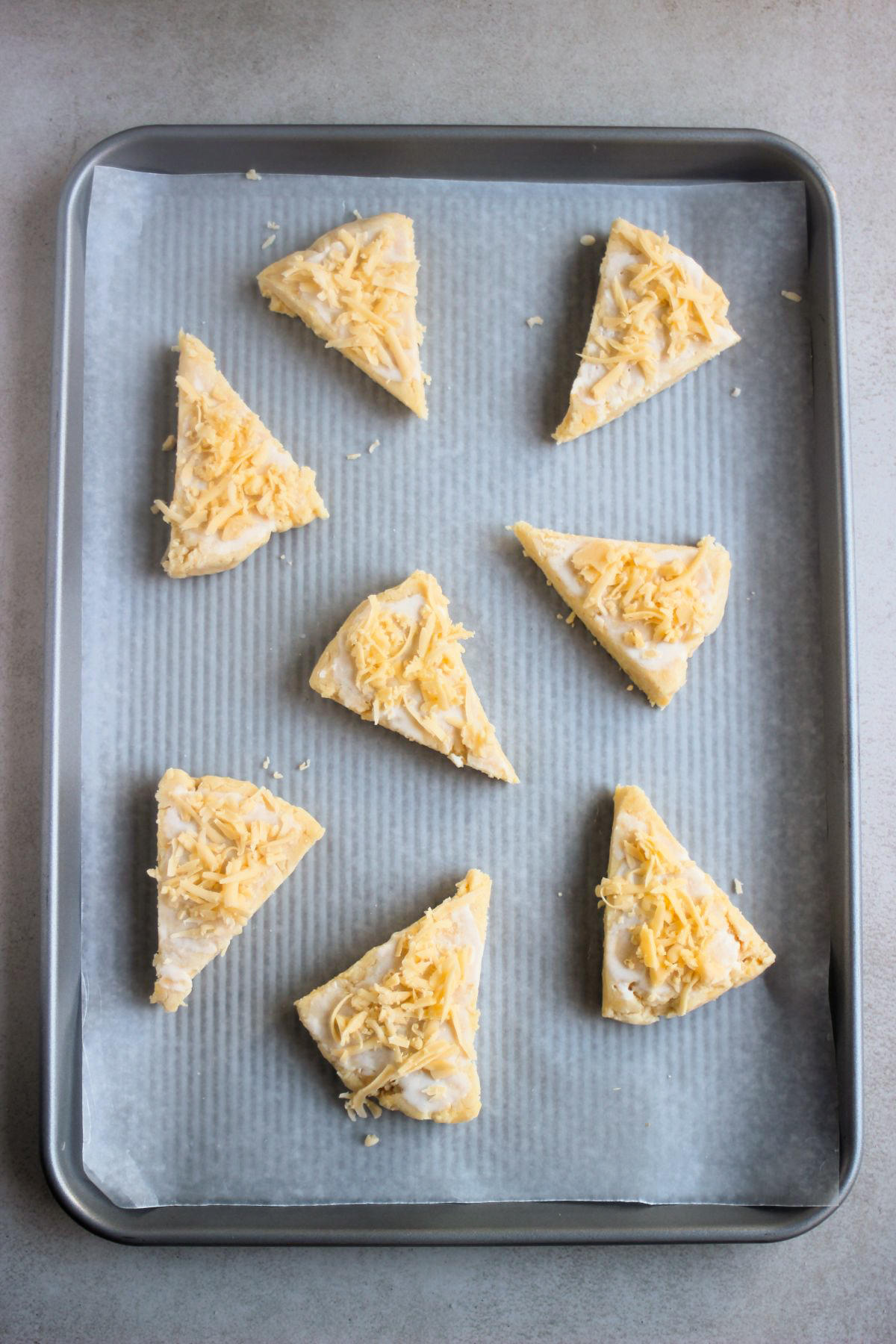 Cheese scones on a baking sheet befores baking.