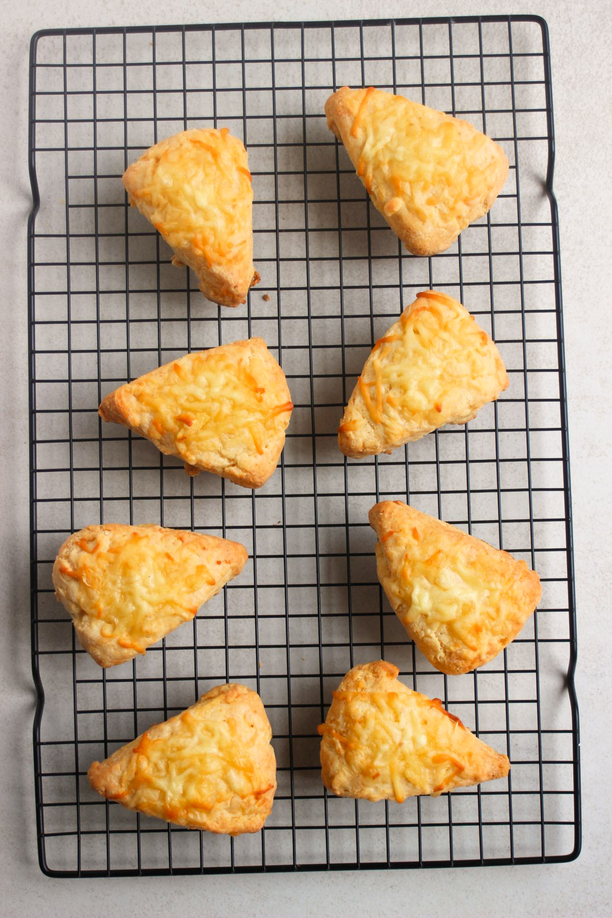 Cheese scones on a wire rack.