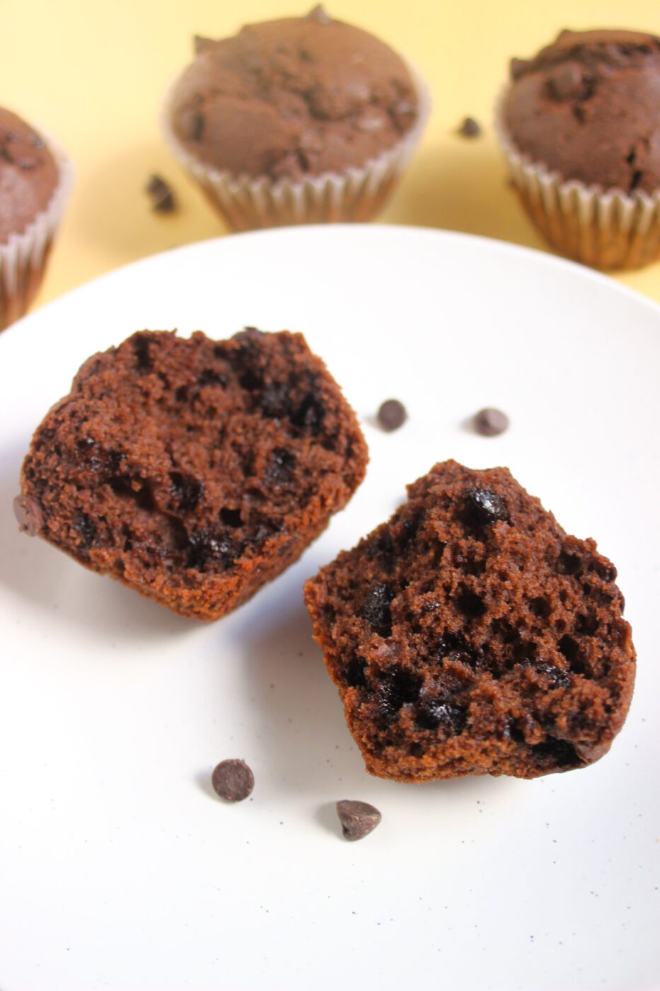 Chocolate buckwheat muffin cut in half on a white plate.