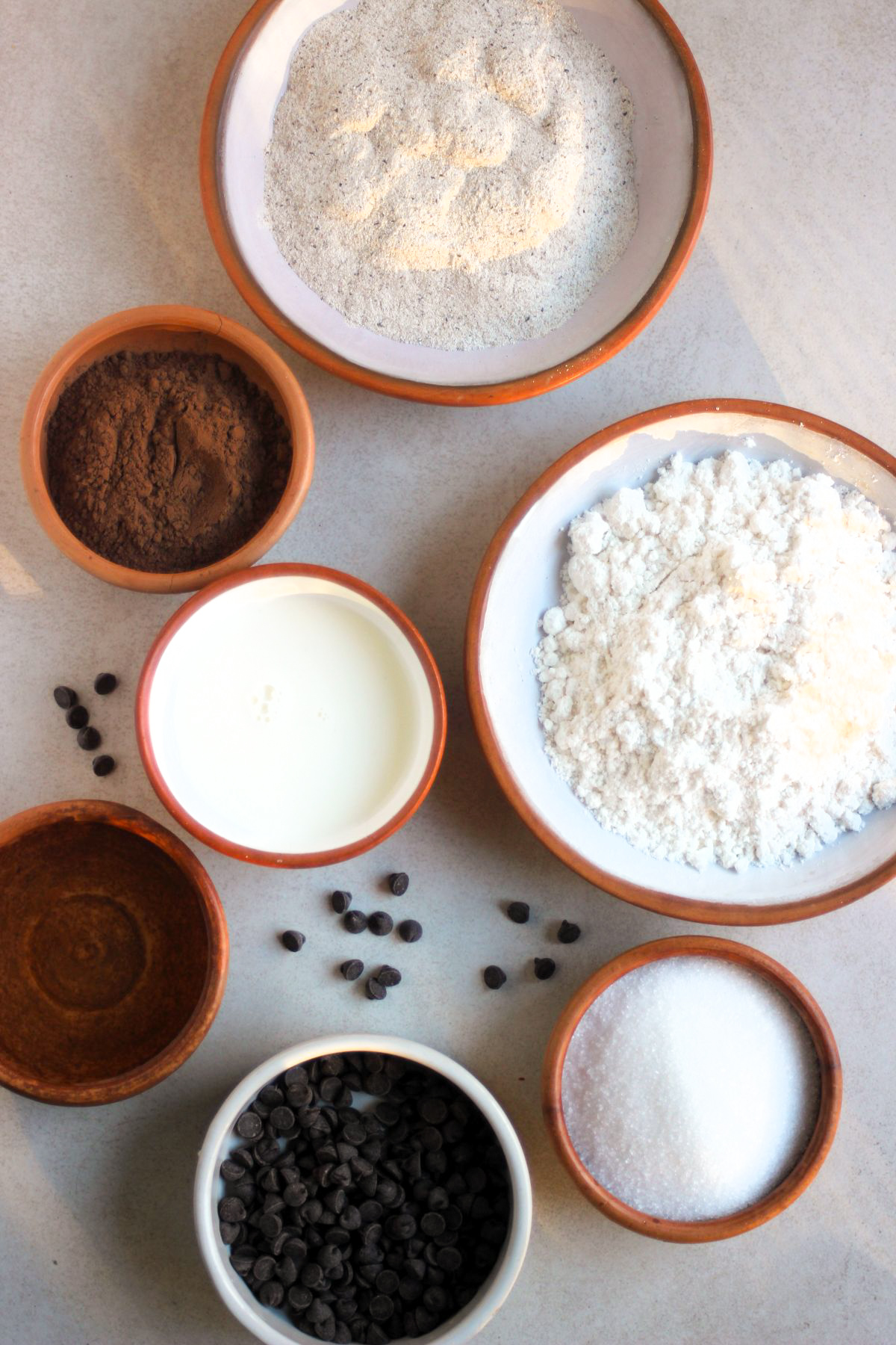 Top view of chocolate buckwheat muffins ingredients on a white surface.