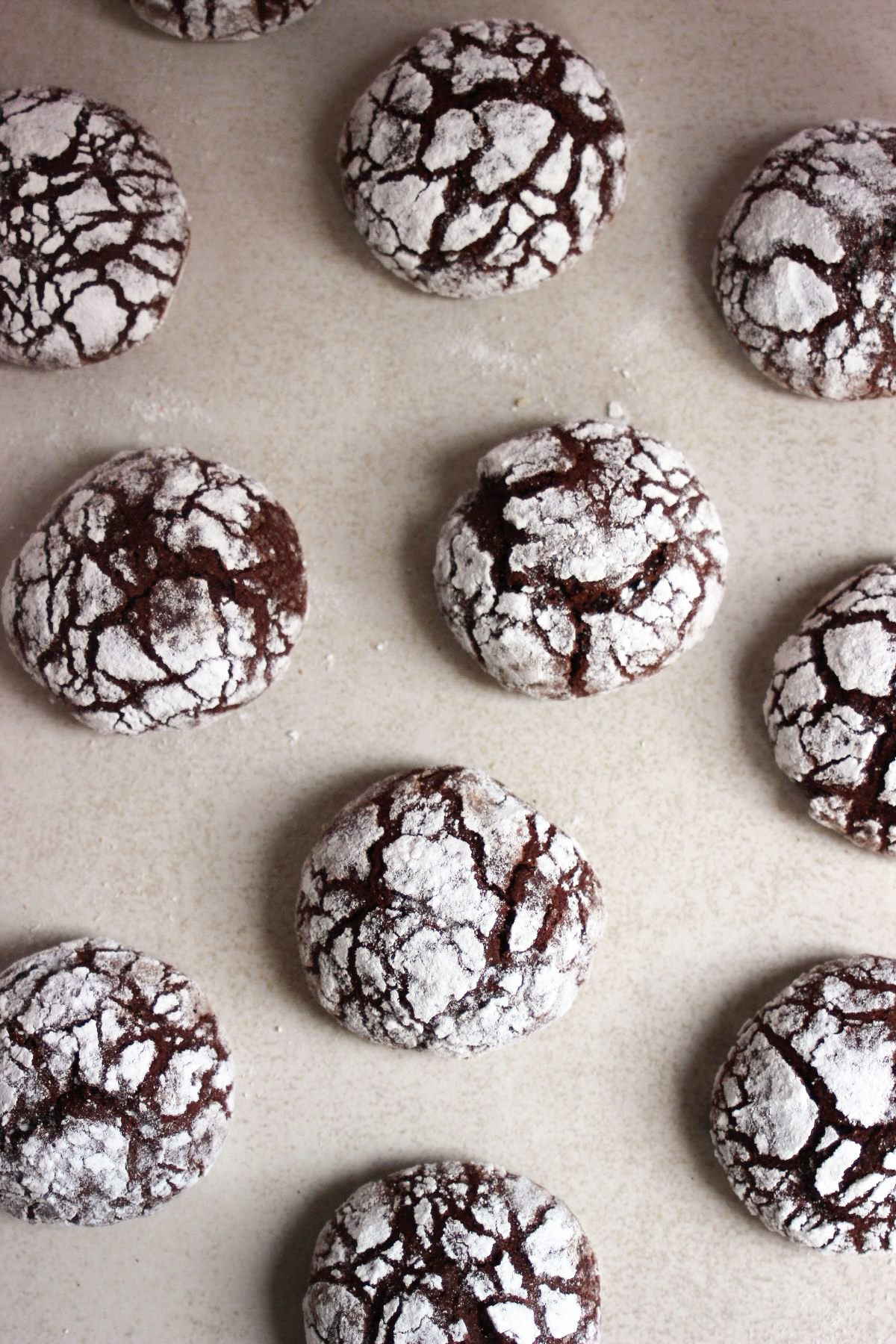 Chocolate crinkle cookies on a white surface.