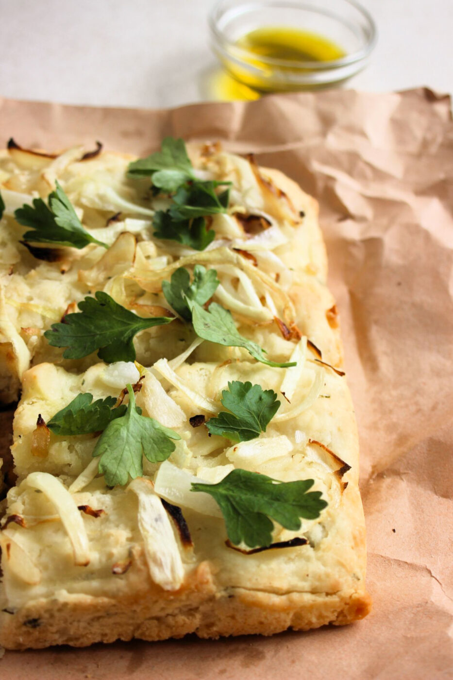 Partial view of onion focaccia on a kraft paper.