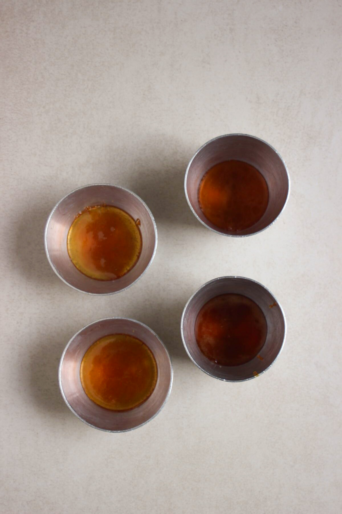 Top view of four flan molds with caramel.