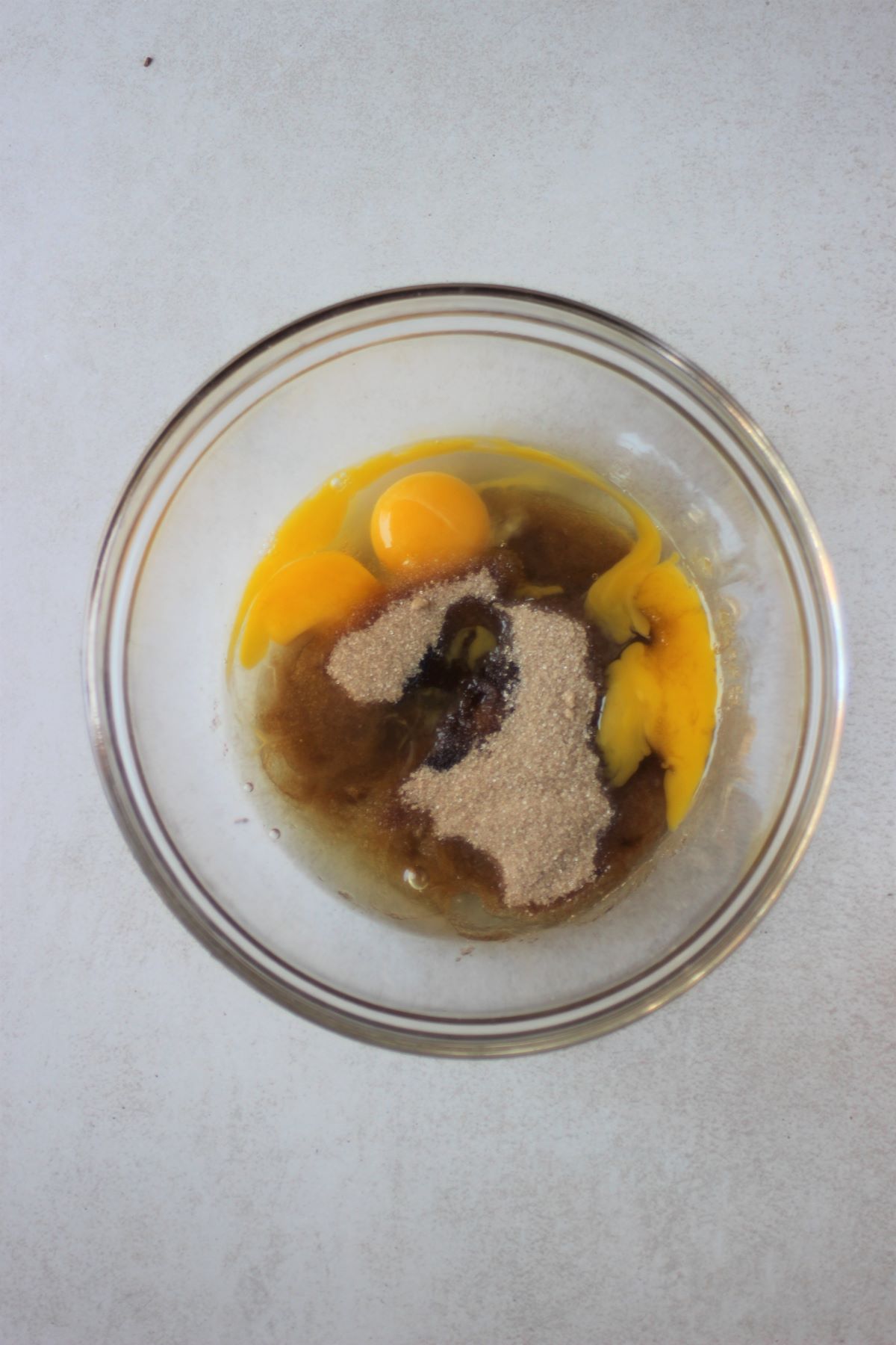 Glass bowl with brown sugar, whites, and egg yolks.