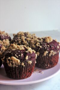 Chocolate beet muffins with brown sugar crumble in a pink plate.