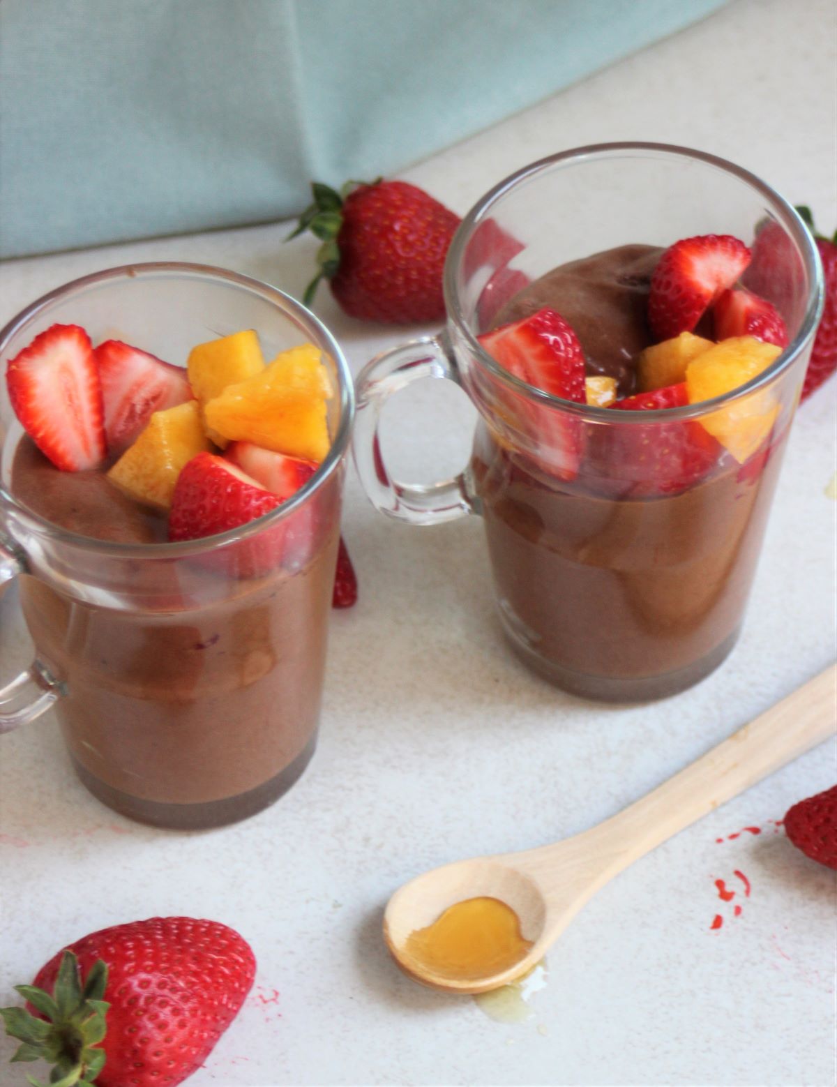 Glass cups with chocolate mousse, strawberries, and peaches. Strawberries on the side..