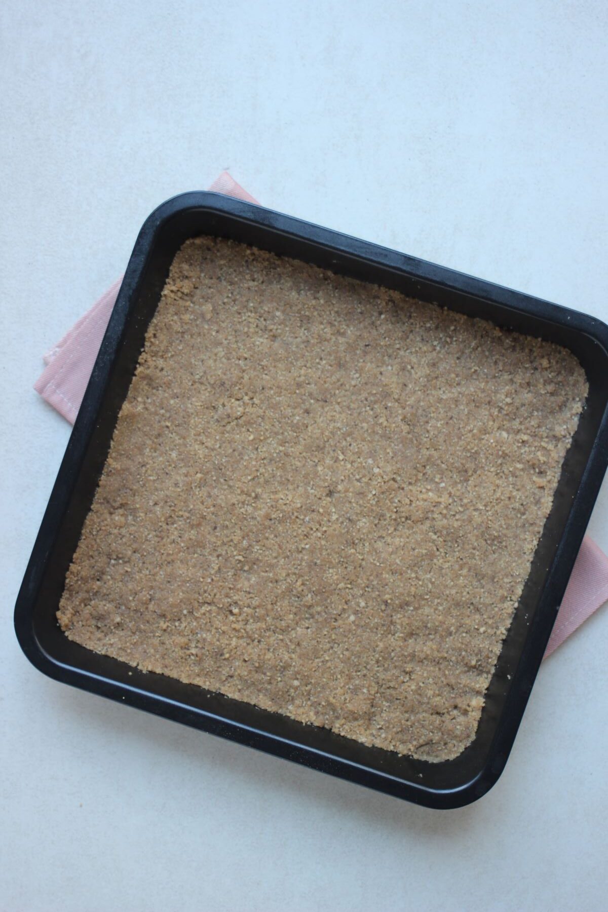 Square bake sheet with a base of cookies.