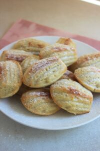 Many madeleines in a white plate.