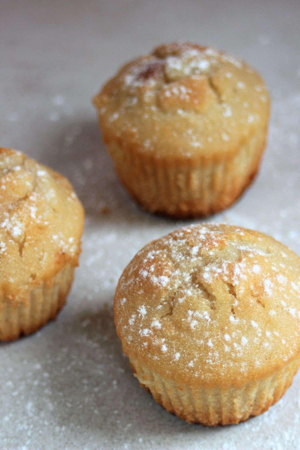 Pear and ginger muffins on a white surface.