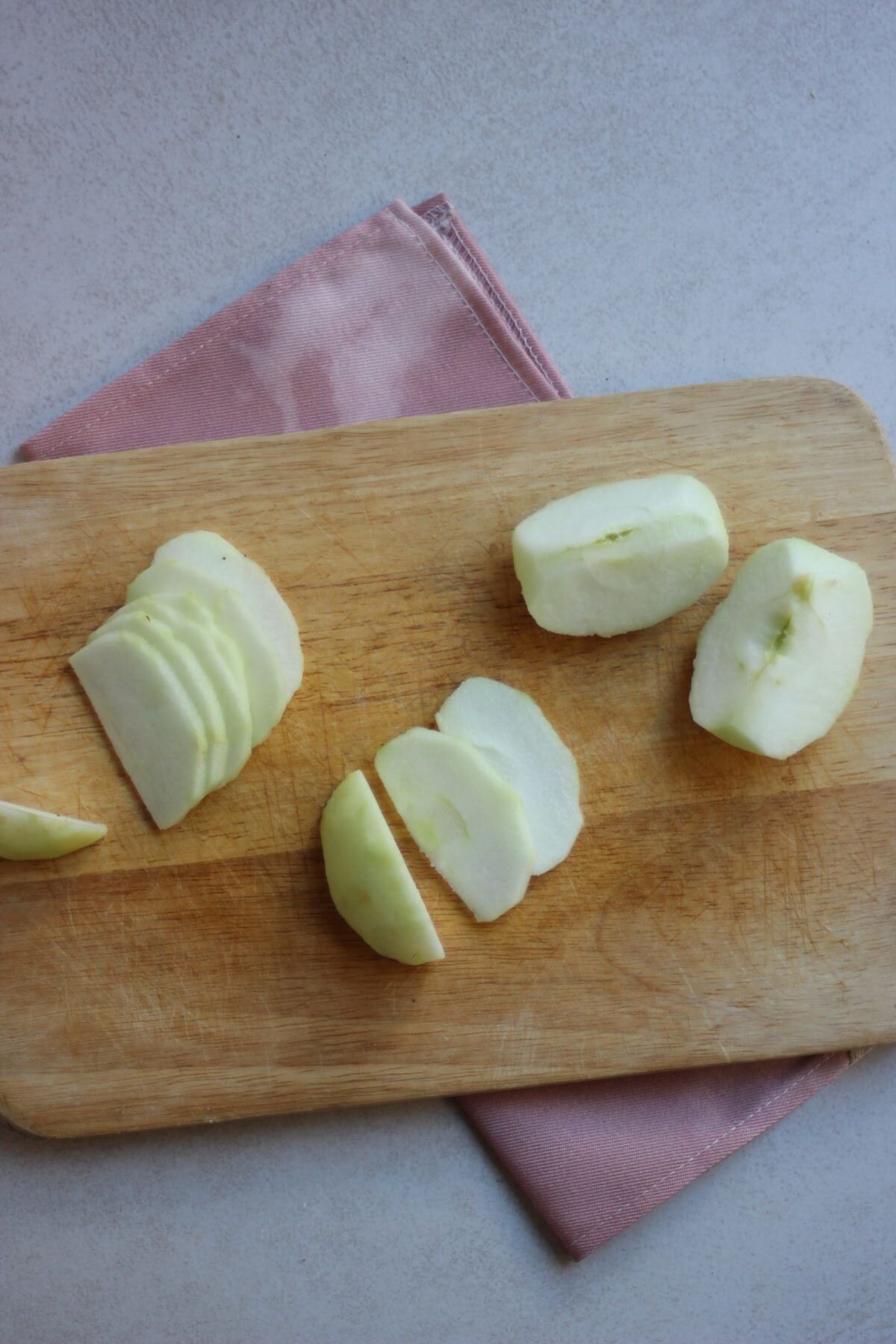Slices apples on a wooden board.