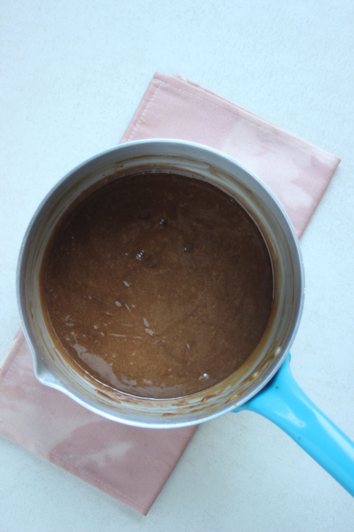 A deep saucepan with chocolate cream.