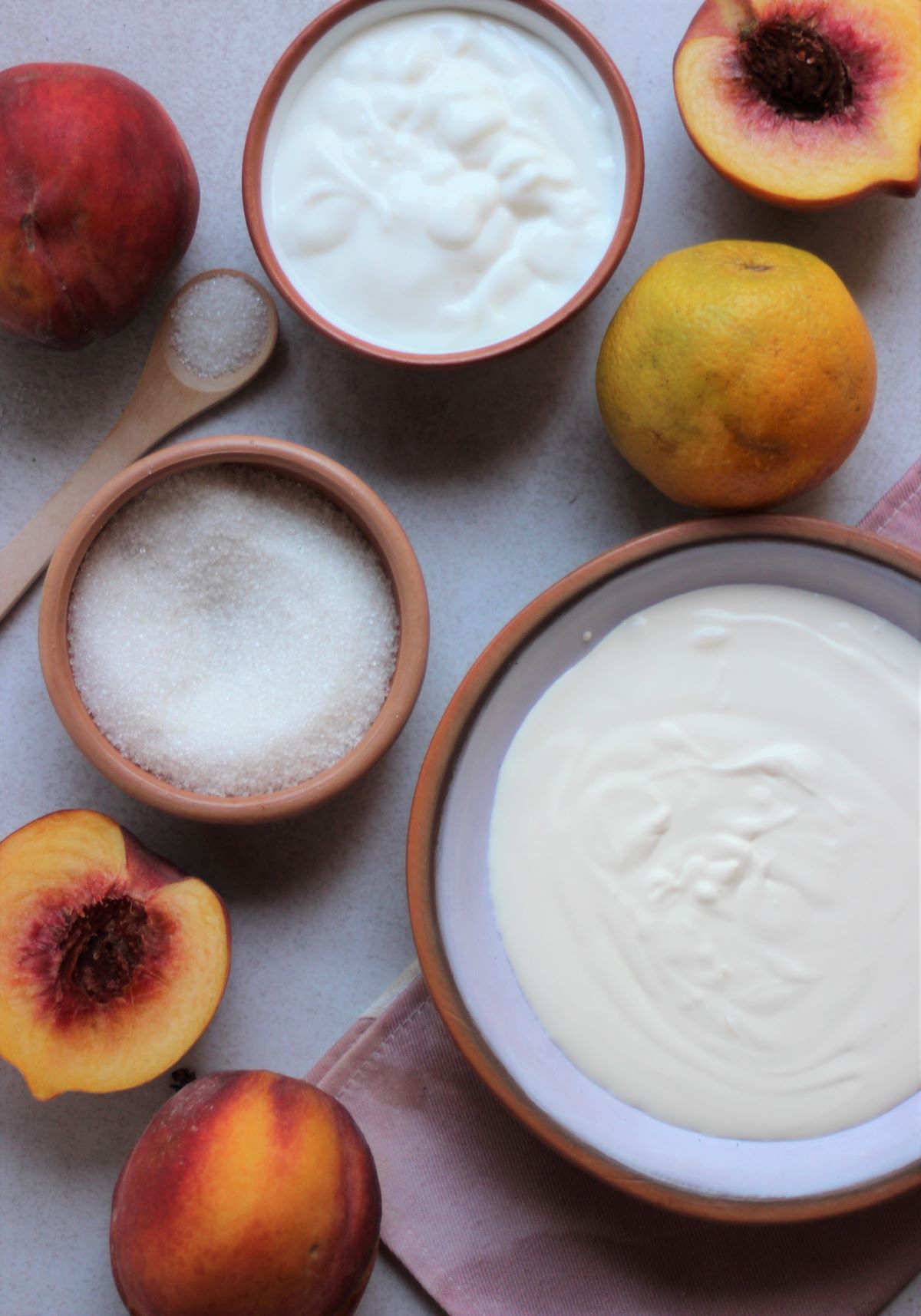 Yogurt, peaches and almond trifle ingredients seen from above.