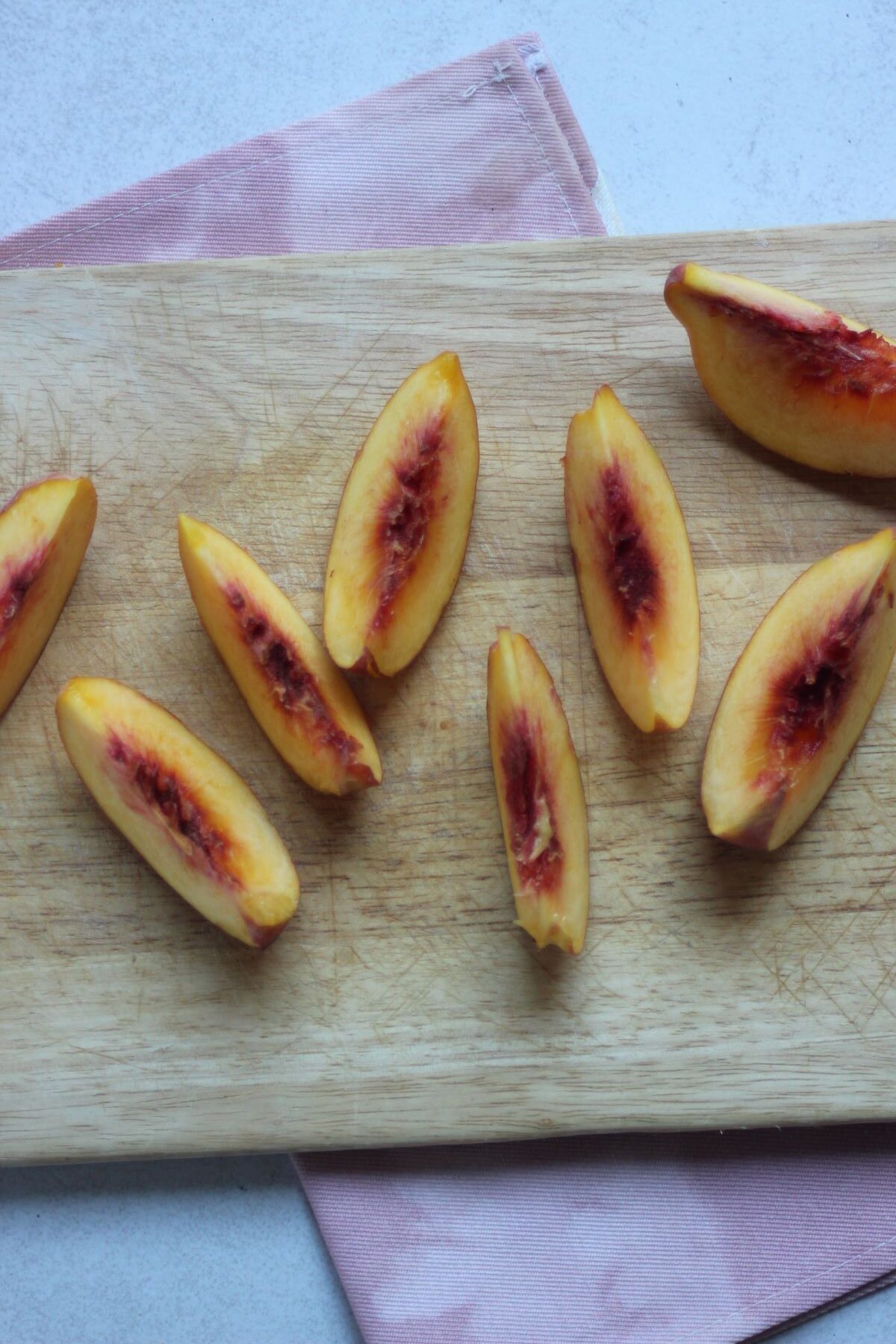 Sliced peaches on a wooden board.