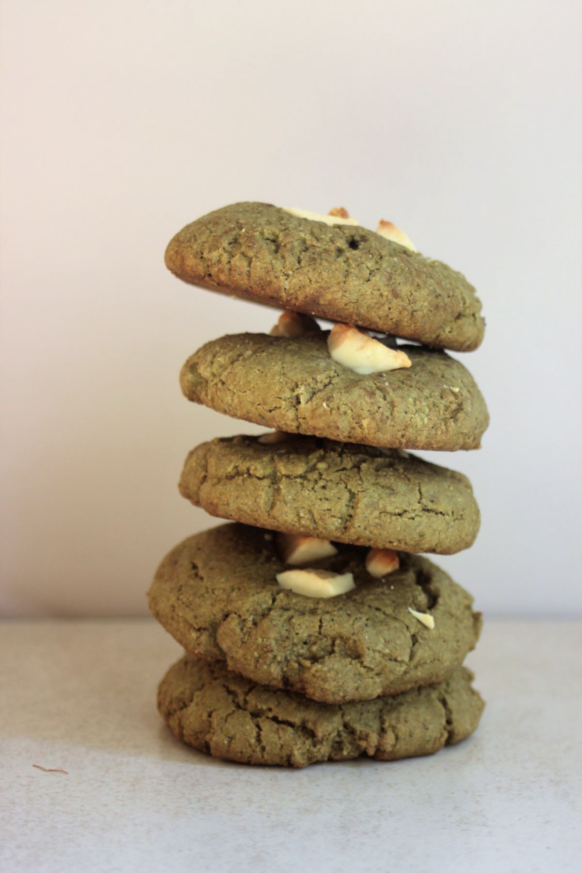 A tower of matcha cookies with white chocolate chunks.