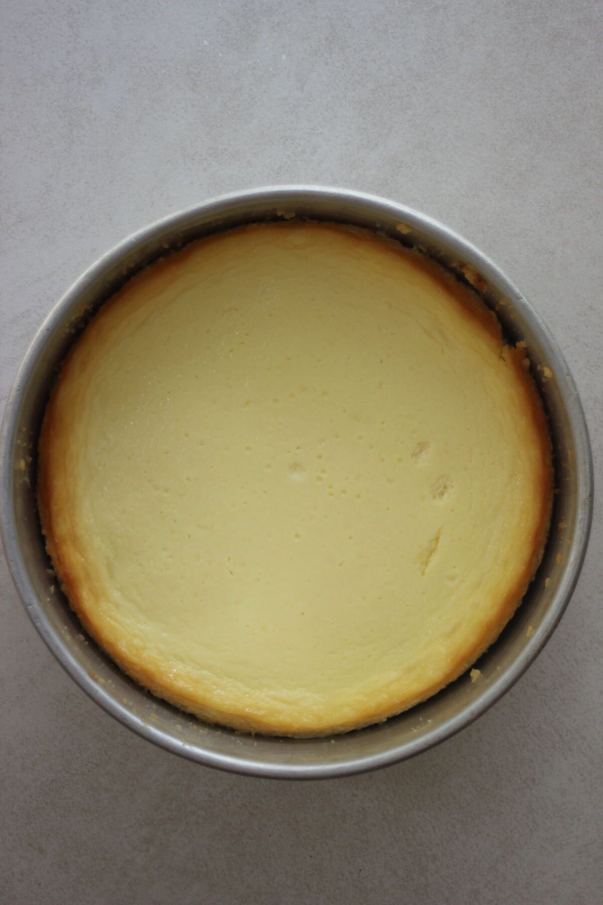 Cooked white chocolate cheesecake in the springform pan seen from above.