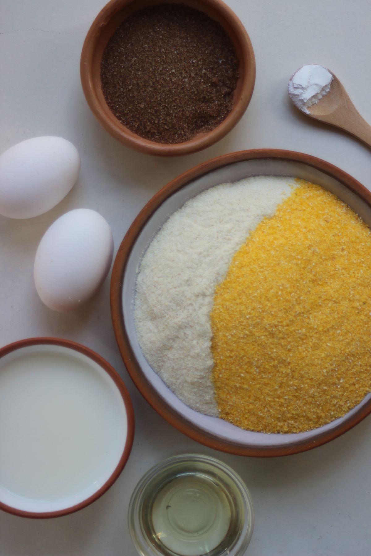 Corn bread ingredients on a white surface seen from above.