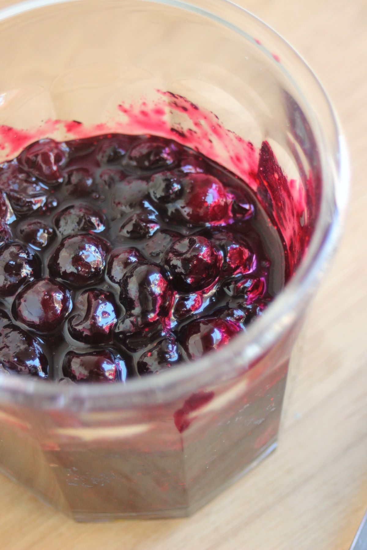 View of the inside of a jar with blueberry sauce.