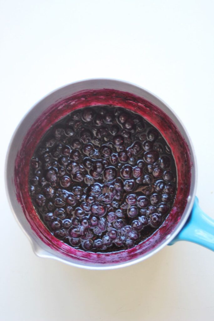 A saucepan with blueberry sauce seen from above.