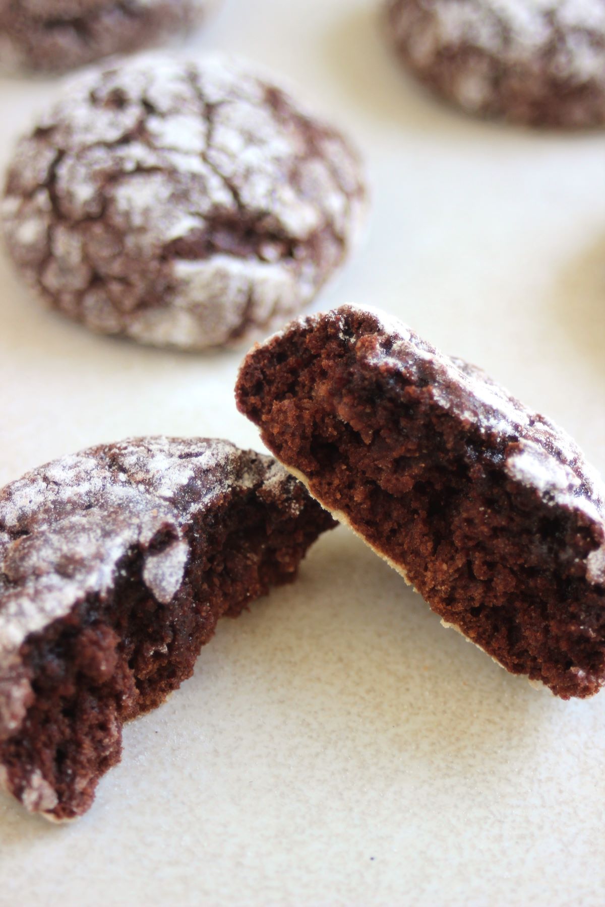 A chocolate crinkle cookie cut into two pieces.