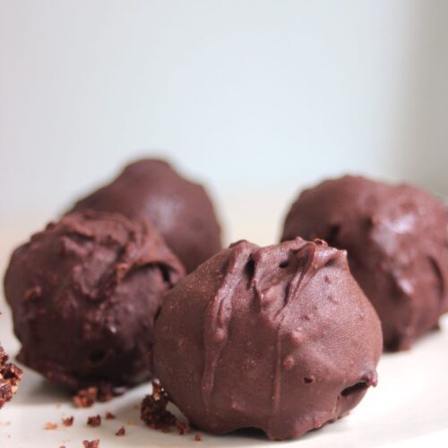 Chocolate peanut butter balls on a white plate.