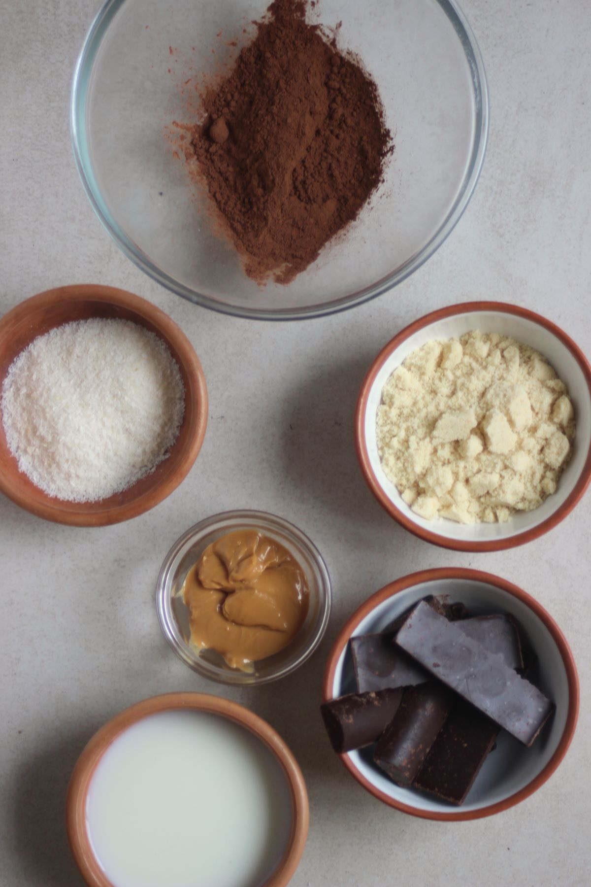 Chocolate peanut butter balls ingredients in different plates seen from above.